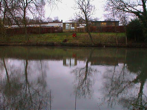 The site viewed from the far side of the pond